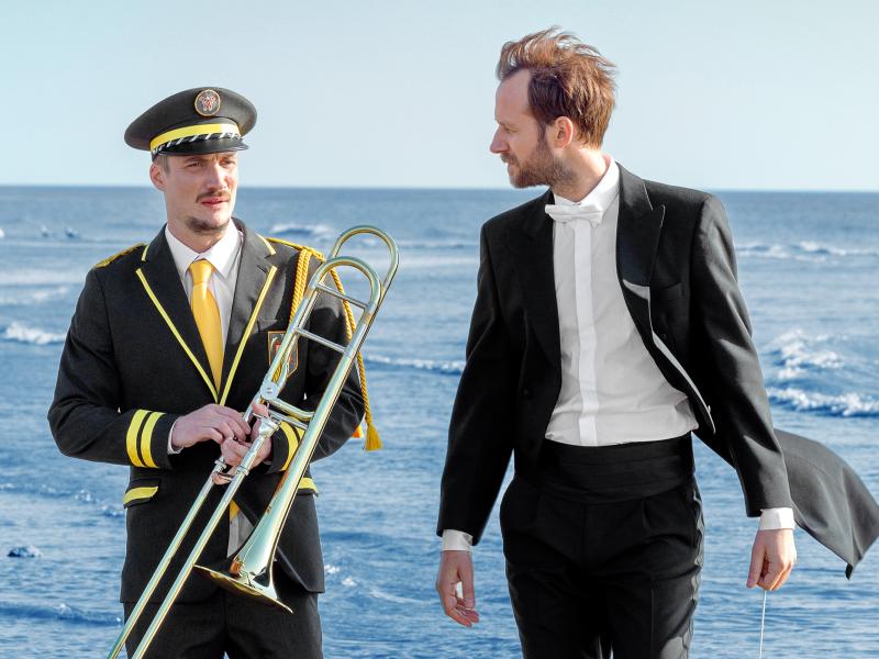 to mænd, musikanter, står på stranden