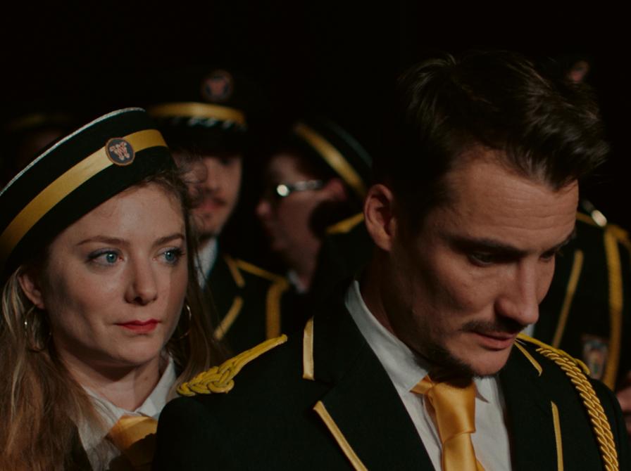 en mand i forgrunden, en kvinde bag ham, resten af et band bag dem